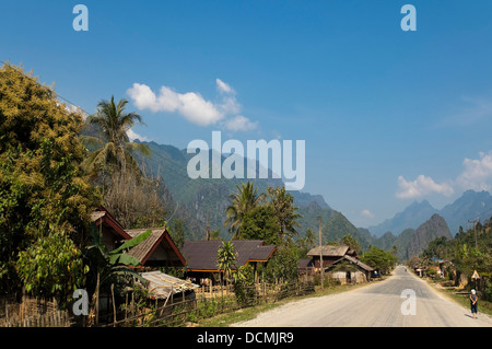 Vista orizzontale delle tradizionali case di legno lungo una strada vicino a Vang Vieng. Foto Stock