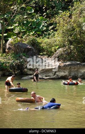 Chiudere verticale dei tubi di turisti lungo Nam Song river vicino a Vang Vieng, post repressione del governo. Foto Stock