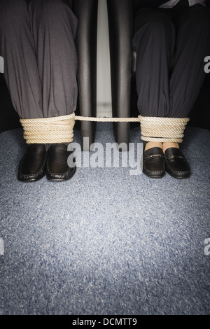 Maschio e femmina la gente di affari per le gambe legato Foto Stock