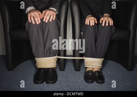 Maschio e femmina la gente di affari per le gambe legato Foto Stock