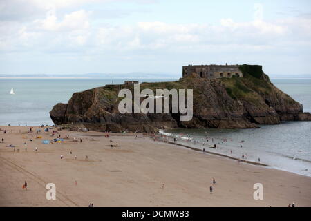 Tenby UK, Lunedì 19 Agosto 2013 un gabbiano battenti infront di Santa Caterina, isola che si affaccia sulla spiaggia del Nord in Tenby Pembrokeshire. Re: Gabbiani visualizzando il comportamento aggressivo in corrispondenza di una nazione più famose stazioni balneari hanno richiesto le chiamate per un "Gabbiano cull" - tra paure per la pubblica sicurezza. Consiglieri in Tenby dire gabbiani reali in città stanno attaccando costruttori sui tetti e le famiglie sulle spiagge. La città il sindaco di querelare Lane ha chiesto che le autorità locali di essere avvicinato per vedere se vi è stato un modo di controllare il belligerante degli uccelli. Credito: D Legakis/Alamy Live News Foto Stock