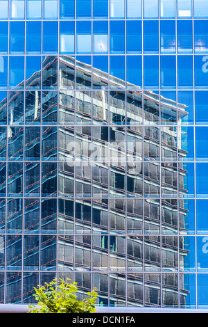Un moderno ed alto edificio di vetro ufficio edificio si riflette in un altro sull'altopiano di Kirchberg, nella città di Lussemburgo. Foto Stock