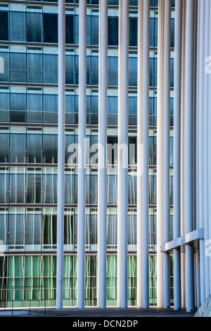 Il bianco delle colonne di acciaio della sala concerti Philharmonie nella città di Lussemburgo con un ufficio moderno edificio che si trova dietro. Foto Stock