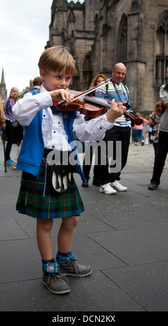 Edimburgo, Scozia, 20 agosto 2013, Colin McGlynn da Virginia, Stati Uniti d'America a sette anni di età potrebbe essere il più giovane busker sulla Royal Mile durante la Edinburgh Fringe Festival 2013. Ha intrattenuto i passanti suonando musiche scozzesi sul suo violino Foto Stock