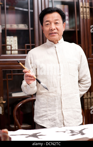 Senior man praticando la calligrafia in studio Foto Stock