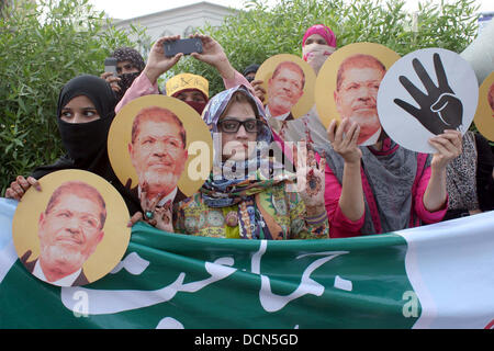 Gli attivisti del Jamat-e-Islami stanno dimostrando per esprimere la loro solidarietà con il popolo d'Egitto e i sostenitori di morsi, a M.A Jinnah Road a Karachi in Pakistan . In Egitto è stato visto a meno di tre anni fa come una potenziale fonte di tanto atteso democrazia araba. Ora sembra essere cade a pezzi. Foto Stock