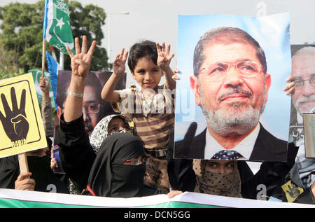 Gli attivisti del Jamat-e-Islami stanno dimostrando per esprimere la loro solidarietà con il popolo d'Egitto e i sostenitori di morsi, a M.A Jinnah Road a Karachi in Pakistan . In Egitto è stato visto a meno di tre anni fa come una potenziale fonte di tanto atteso democrazia araba. Ora sembra essere cade a pezzi. Foto Stock