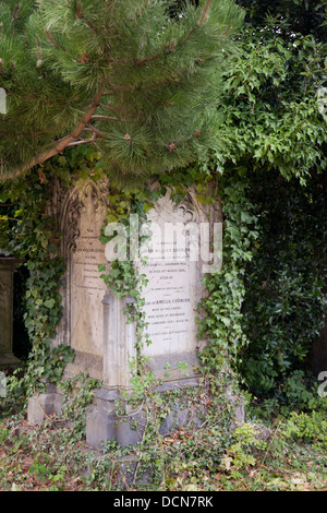 Vecchio headstone ricoperti di edera e di alberi, dell'Arno Vale cimitero, Bristol, Inghilterra Foto Stock