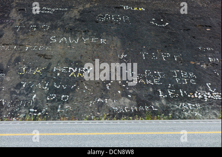 I bambini utilizzano rocce bianche sulla collina di nero per creare i segni e nome, Glenn Highway, Highway 1, Alaska Foto Stock