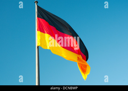 Bandiera nazionale della Germania contro il cielo blu come sfondo Foto Stock