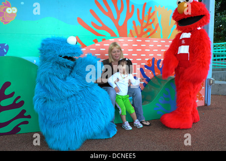 Cookie Monster e Elmo salutare giovane ragazza al mondo del mare Foto Stock