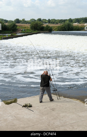 Un uomo regolando il suo canne da pesca Beeston weir Nottingham England Regno Unito Foto Stock