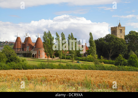 Quattro forno convertito Oast House e Chiesa Horsmonden Kent England Regno Unito Foto Stock