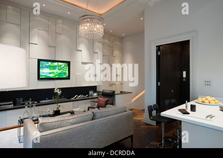 Area con posti a sedere con lampadario in vetro di Londra City Apartment Foto Stock