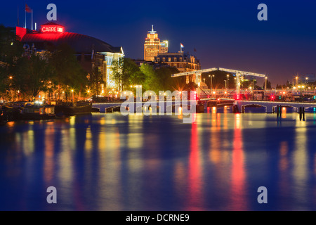 Ora blu di Amsterdam con la vista del Magere Brug (Skinny Bridge) e Teatro Carre dopo il tramonto. Foto Stock