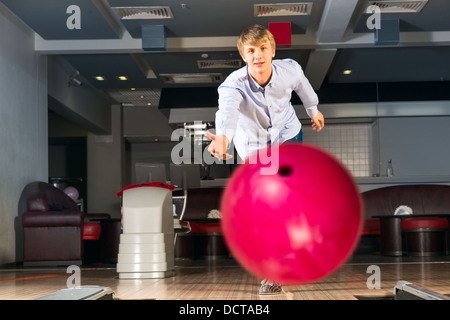 Giovane uomo giocare a bowling Foto Stock