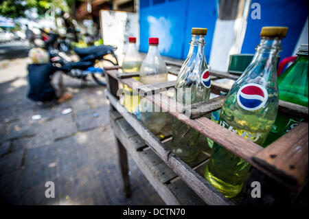 Gen 3, 2013 - Phnom Penh Cambogia - Jan 3, 2013 - Il carburante è spesso venduto da litro in soda utilizzate bottiglie di bevande a lato della strada si erge, convient per il passaggio di biciclette in Cambogia la città capitale di Phnom Penh. ..Storia Sommario: tra il ritmo febbrile di Phnom PenhÃ• per le strade delle città, un cavallo da tiro di trasporto per persone e merci emerge: biciclette, moto, scooter, ciclomotori, motodups e Tuk Tuks vagare nel luogo di automobili e camion. Quasi il 90 percento dei veicoli il roaming capitale cambogiana di quasi 2,3 milioni di persone a scegliere questi per arrivare a. La congestione del traffico e ambiente sia beneficiare fr Foto Stock