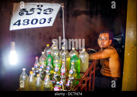 Gen 8, 2013 - Phnom Penh Cambogia - Jan 8, 2013 - Il carburante è spesso venduto da litro in soda utilizzate bottiglie di bevande a lato della strada si erge, convient per il passaggio di biciclette in Cambogia la città capitale di Phnom Penh. ..Storia Sommario: tra il ritmo febbrile di Phnom PenhÃ• per le strade delle città, un cavallo da tiro di trasporto per persone e merci emerge: biciclette, moto, scooter, ciclomotori, motodups e Tuk Tuks vagare nel luogo di automobili e camion. Quasi il 90 percento dei veicoli il roaming capitale cambogiana di quasi 2,3 milioni di persone a scegliere questi per arrivare a. La congestione del traffico e ambiente sia beneficiare fr Foto Stock