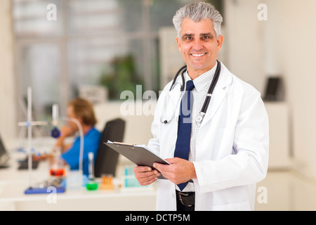 Medico senior in laboratorio tenendo un clipboard Foto Stock