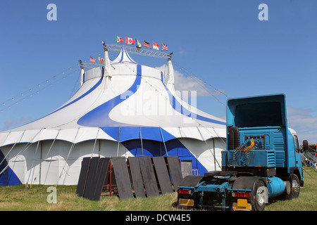 Blu e bianco tenda del circo con autoarticolato in primo piano. Foto Stock