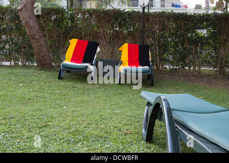 Asciugamani con i colori della bandiera tedesca sono utilizzati per prenotare lettini per prendere il sole in un hotel Foto Stock