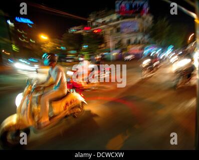 Phnom Penh Cambogia. 21 Ago, 2013. Jan 5, 2013 - equitazione le strade di Phnom Penh cercando notte estiva la vita in Cambogia la città capitale. Buon Kamir ragazze ride sella laterale mentre la crociera le strade della città in cerca di un luogo per vedere ed essere visto.Storia Sommario: tra il ritmo febbrile di Phnom PenhÌ¥ per le strade delle città, un cavallo da tiro di trasporto per persone e merci emerge: biciclette, moto, scooter, ciclomotori, motodups e Tuk Tuks vagare nel luogo di automobili e camion. Quasi il 90 percento dei veicoli il roaming capitale cambogiana di quasi 2. Credito: ZUMA Press, Inc./Alamy Live News Foto Stock