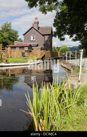 Riflessioni a Brithdir serratura e cottage vicino a Welshpool sul canale di Montgomery, Powys, Wales, Regno Unito Foto Stock