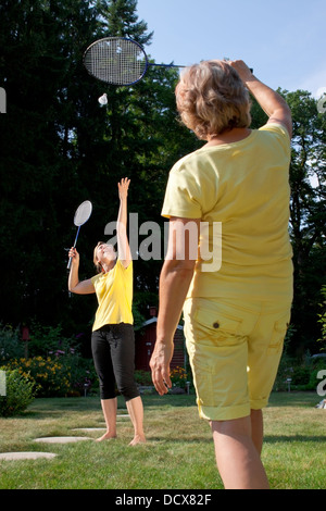 Due donne stanno giocando a badminton in giardino Foto Stock