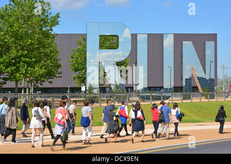 I turisti passeggiando accanto alla sede multisport al coperto Copper Box riaperta nel Queen Elizabeth Olympic Park Hackney Wick East London England UK Foto Stock