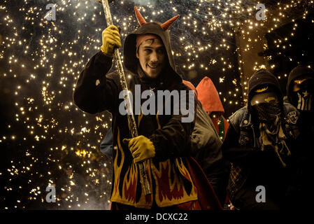 Barcellona, Spagna. 21 Agosto 2013: membro di 'la Vella de Grˆcia" nella sua diavolo vestito set fuori i suoi fuochi d'artificio durante la " Festa Major de Gracia'. Credito: matthi/Alamy Live News Foto Stock