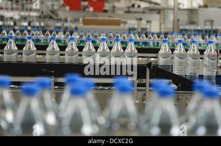 I flaconi sono raffigurate sulla linea di produzione in impianto di imbottigliamento della Coca Cola Erfrischungsgetränke AG impianto di produzione in Genshagen, Germania, 21 agosto 2013. Qui, i prodotti Coca-Cola sono riempiti in imballaggi monouso su 158.000 metri quadrati. 170 dipendenti lavorano nell'impianto di produzione che è stato aperto nel 1998. La Coca-Cola Erfrischungsgetränke AG è una delle più grandi aziende produttrici di bevande in Germania con un volume di vendite di 3,7 miliardi di litri nel 2012. Foto: Jens Kalaene Foto Stock