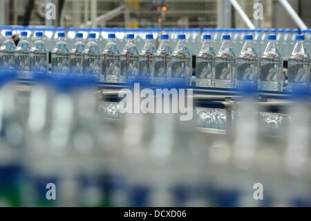 I flaconi sono raffigurate sulla linea di produzione in impianto di imbottigliamento della Coca Cola Erfrischungsgetränke AG impianto di produzione in Genshagen, Germania, 21 agosto 2013. Qui, i prodotti Coca-Cola sono riempiti in imballaggi monouso su 158.000 metri quadrati. 170 dipendenti lavorano nell'impianto di produzione che è stato aperto nel 1998. La Coca-Cola Erfrischungsgetränke AG è una delle più grandi aziende produttrici di bevande in Germania con un volume di vendite di 3,7 miliardi di litri nel 2012. Foto: Jens Kalaene Foto Stock