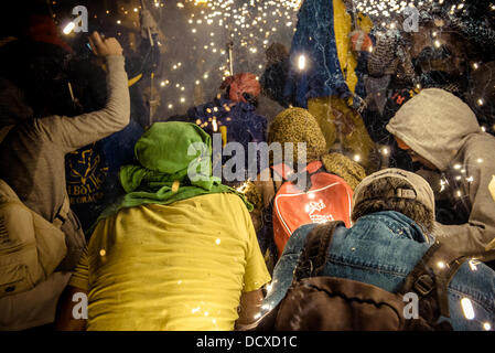 Barcellona, Spagna. 21 Agosto 2013: La danza di folla di spettatori prendere in consegna i fuochi d'artificio durante il 'Correfocs' a 'Festa Major de Gracia'. Credito: matthi/Alamy Live News Foto Stock