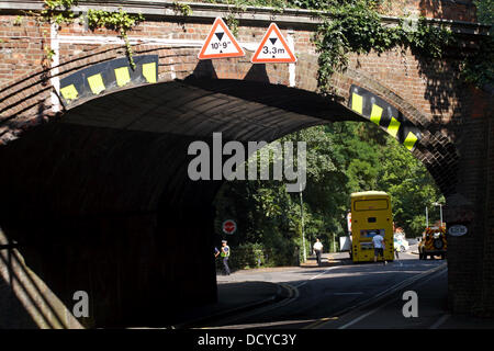 Bournemouth, Regno Unito 22 agosto 2013. Parte di una strada a Westbourne, è stato chiuso dopo un bus divenne intrappolati sotto un ponte ferroviario - un 14 piedi sei autobus cercando di ottenere attraverso 10 piedi nove gap! Il Bus giallo è stato incuneato sotto il ponte; l'aria è stato lasciato fuori i pneumatici e il bus trascinato fuori all'indietro da un veicolo di recupero, lasciando una profonda sgorbie sul ponte. Il bus in questione è stata di non in servizio. Lo spigolo anteriore del bus incrinato sotto la pressione e la parte superiore ripiegata al lato anteriore sinistro. Credito: Carolyn Jenkins/Alamy Live News Foto Stock