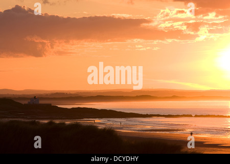 Trinità Lighthouse, tramonto, Bamburgh, Northumberland, Regno Unito Foto Stock