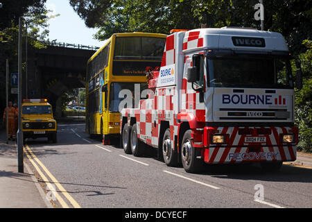 Bournemouth, Regno Unito 22 agosto 2013. Parte di una strada a Westbourne, è stato chiuso dopo un bus divenne intrappolati sotto un ponte ferroviario - un 14 piedi sei autobus cercando di ottenere attraverso 10 piedi nove gap! Il Bus giallo è stato incuneato sotto il ponte; l'aria è stato lasciato fuori i pneumatici e il bus trascinato fuori all'indietro da un veicolo di recupero, lasciando una profonda sgorbie sul ponte. Il bus in questione è stata di non in servizio. Lo spigolo anteriore del bus incrinato sotto la pressione e la parte superiore ripiegata al lato anteriore sinistro. Credito: Carolyn Jenkins/Alamy Live News Foto Stock