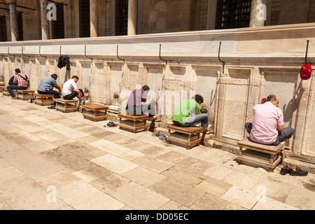 Gli uomini lavando loro i piedi in preparazione per la preghiera, alla Moschea Suleymaniye, Istanbul, Turchia Foto Stock