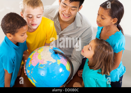 Gruppo di studenti adorabile con insegnante guardando il mondo Foto Stock