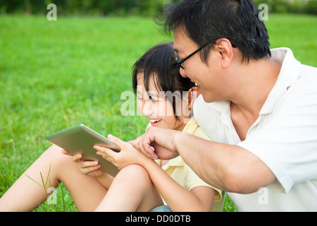 Padre insegnamento bambina utilizzando tablet pc Foto Stock