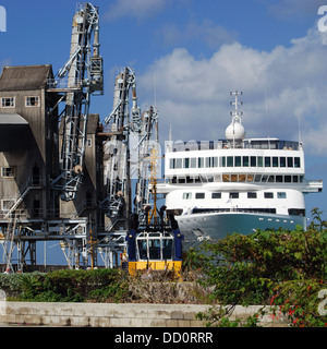 Prua di nave da crociera (Braemar) con fila di gru di banchina in primo piano, Bridgetown, Barbados, dei Caraibi. Foto Stock