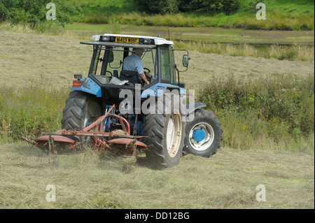 Un Pottinger Kombi 401 Voltafieno lavorando sulla parte posteriore di un trattore agricolo England Regno Unito Foto Stock