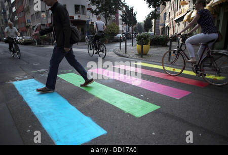 Colonia, Germania. 23 Ago, 2013. Un uomo che va oltre un crosswalk dipinte in colori Arcobaleno a Colonia, Germania, 23 agosto 2013. Presumibilmente, lo sfondo è un azione di protesta contro la Russia di trattamento a danno degli omosessuali. Un crosswalk davanti all'ambasciata russa di Oslo è stata verniciata nei colori dell'arcobaleno. Foto: OLIVER BERG/dpa/Alamy Live News Foto Stock