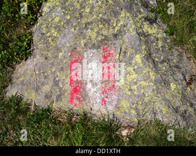 Un rosso e bianco marcatura dipinta su una roccia di muschio, su un sentiero vicino a Innsbruck, Austria Foto Stock