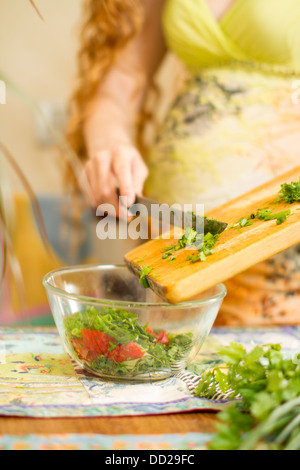 Donna s mani il taglio di cipolle fresche aneto prezzemolo su cucina Focus sulla verdura verde il concetto di cibo e di uno stile di vita sano Foto Stock