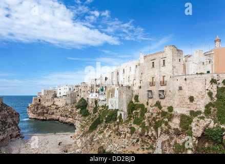 La suggestiva scogliera-top comune di Polignano a Mare in Puglia, Italia meridionale con le sue case dipinte di bianco e la spiaggia sassosa Foto Stock