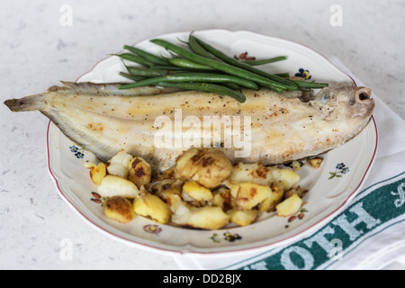 Suola di dover grigliata presentata su un piatto di porcellana servito all'osso con patate novelle saltate e fagiolini Foto Stock