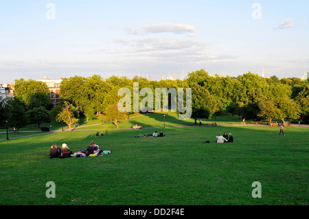 Le persone a rilassarsi in Primrose Hill durante la stagione calda a Londra, Regno Unito Foto Stock