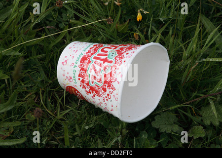Figliata. Un bicchiere di carta è stato scartato sull'erba e sinistra. Foto Stock