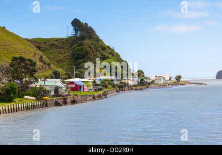 Case vacanza o baches accanto al fiume Tongaporutu, Taranaki, Nuova Zelanda. Foto Stock