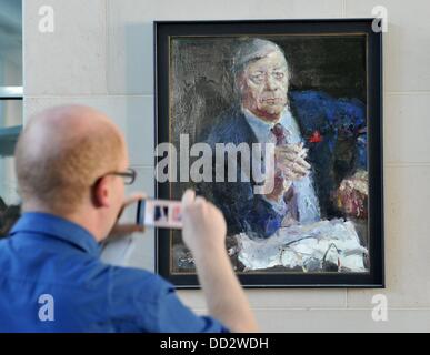 La gente guarda un ritratto dell'ex cancelliere tedesco Helmut Schmidt presso la cancelleria durante la casa aperta giorno del governo tedesco a Berlino, Germania, 24 agosto 2013. Foto: PAOLO ZINKEN Foto Stock